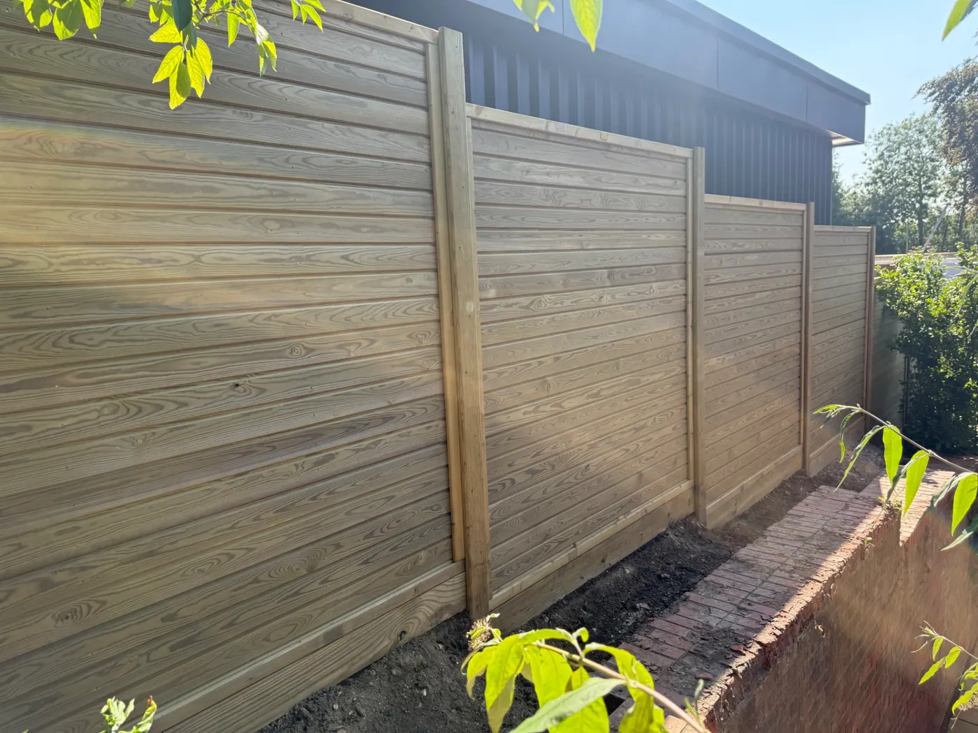 Horizontal tongue and groove fence panels installed in a garden